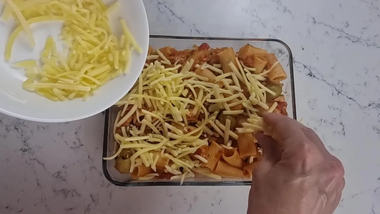 Adding cheese to the top of the pasta bake