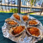 6 grilled nduja oysters on a serving plate